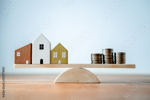 Balance scale Wooden plank of wood small home and coins money, comparison of income control expense saving money. Property investment and house mortgage. Personal financial planning concept
