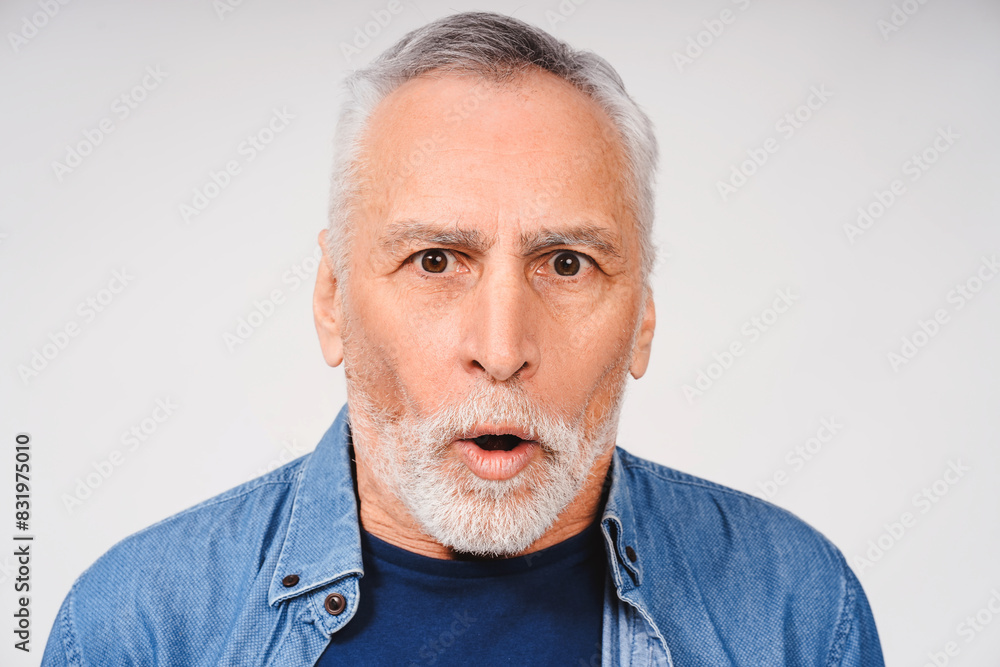 Shocked gray-haired bearded adult man posing looking at camera isolated on white background Shocked gray-haired bearded adult man posing looking at camera isolated on white background