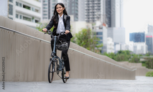 Smart businesswoman ride bicycle in downtown. Environmentalist commuting by cycling reduce carbon footprint global warming. Bike to work eco friendly alternative transportation green energy vehicle