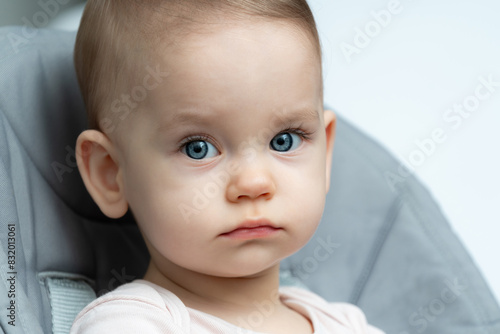 Close-up of a toddler baby gazing at the camera with calm face