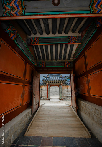 Obraz na płótnie A colonnade at the Geunjeongmun Gate (or third gate) of the Gyeongbokgung Palace complex in Seoul, Korea shows the row of red columns topped by ornately painted wood beams. w salonie