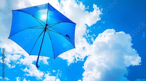 A blue umbrella soaring in the air against a blue sky