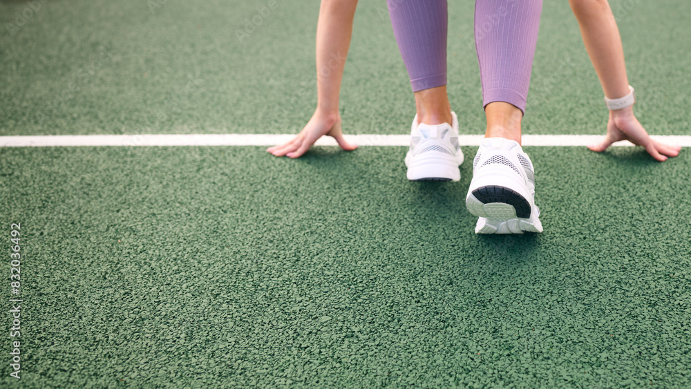 Close Up Of Female Athlete With Feet On Starting Line Before Start Of Race