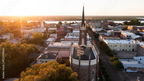 Fotografía Natchez, Mississippi, USA - April 21, 2024: Sunset light shines on a historic church and landscape of downtown Natchez
