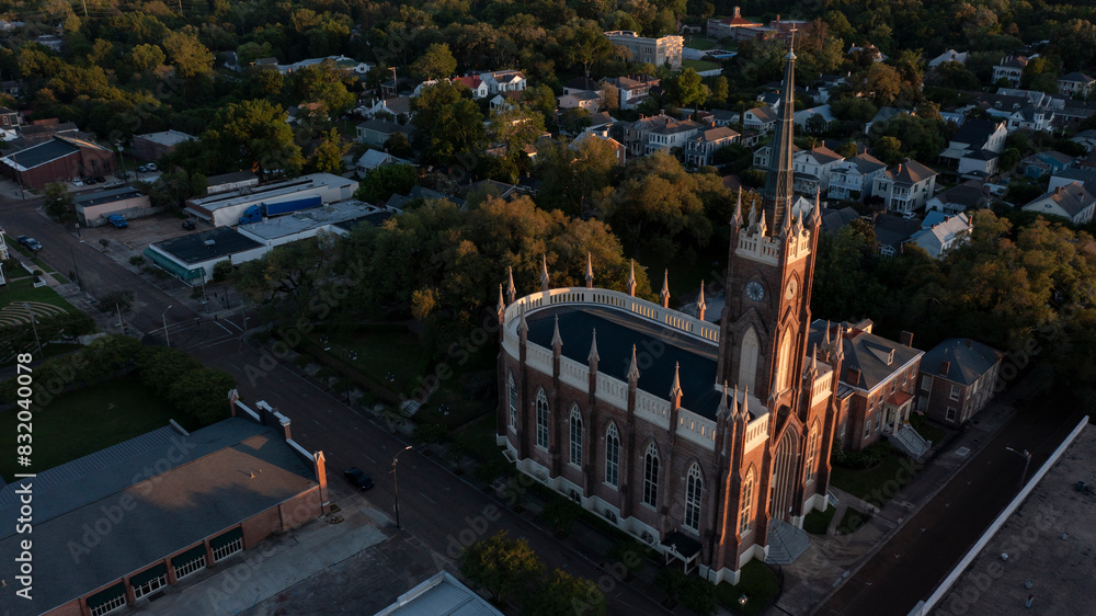 Fototapeta premium Natchez, Mississippi, USA - April 21, 2024: Sunset light shines on a historic church and landscape of downtown Natchez.