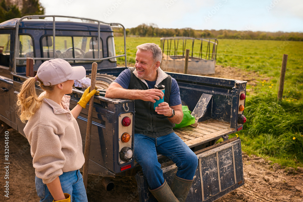 Mature Male Farm Worker Sitting On Tailgate Of Off Road Farm Vehicle Talking With Female Colleague Mature Male Farm Worker Sitting On Tailgate Of Off Road Farm Vehicle Talking With Female Colleague