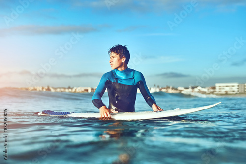 Teenager, boy and surfing with waves, summer and happiness with fitness, water and seaside. Surfer, athlete and vacation with holiday, adventure and getaway trip with ocean, travelling and excited