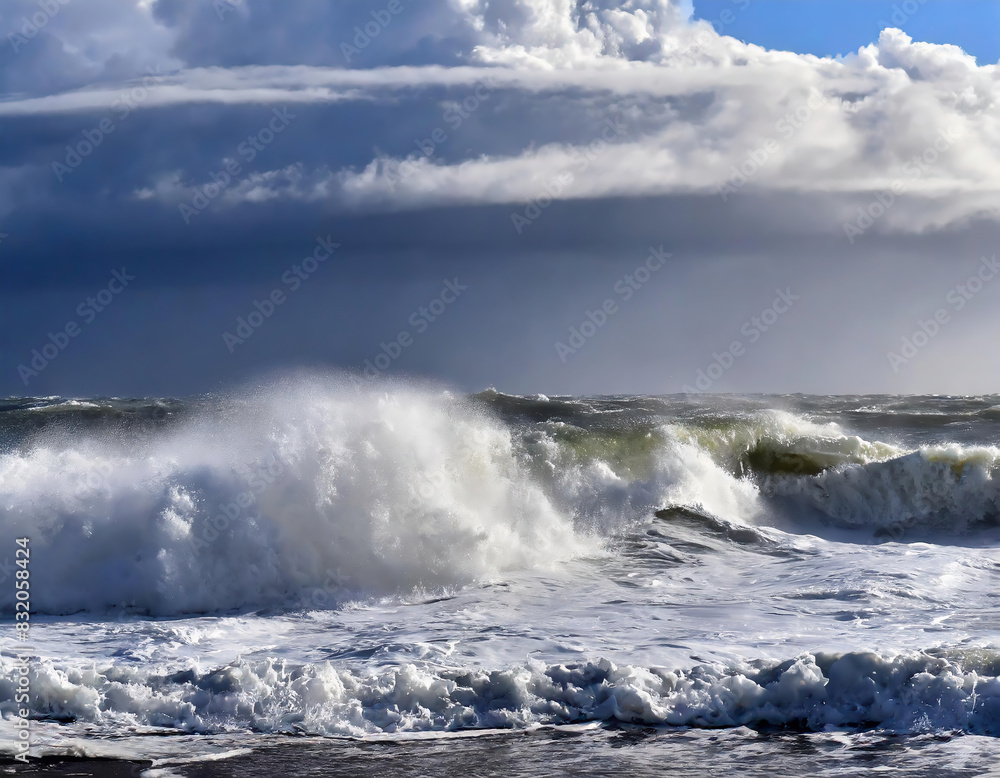 Stormy seascape, powerful waves crashing the sandy beach on the shoreline