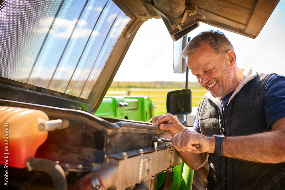 Close Up Of Mature Male Farm Worker Fixing Machinery Close Up Of Mature Male Farm Worker Fixing Machinery