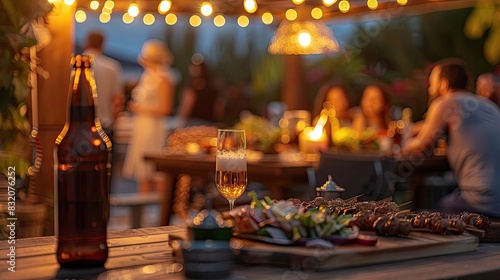 Outdoor gathering with string lights, food, and drinks. People enjoying a warm evening in a cozy, festive atmosphere. photo