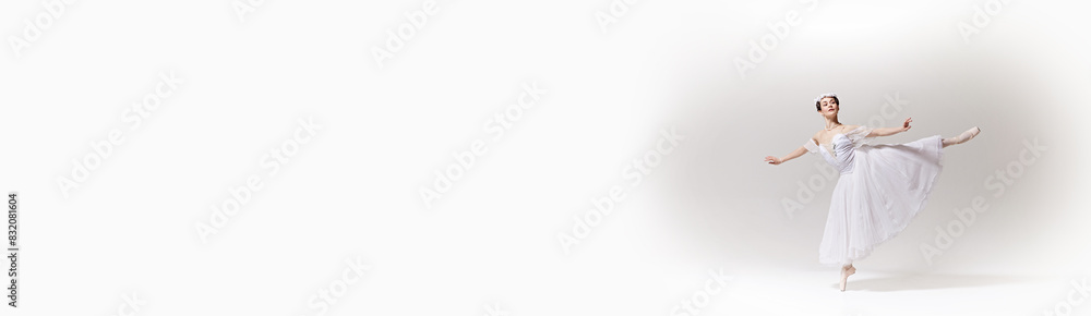 Banner. Graceful woman, ballerina in white dress floats in dance, demonstrating elegance and skill against white studio background. Concept of art, fusion of classic and modernity, grace and elegance. Banner. Graceful woman, ballerina in white dress floats in dance, demonstrating elegance and skill against white studio background. Concept of art, fusion of classic and modernity, grace and elegance.