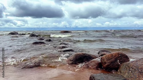 slow motion video of beating waves at the beach. Rocky shore of finland gulf photo