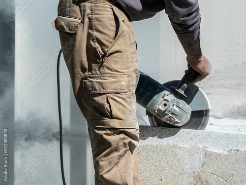 detail of a worker using a radial saw to cut granite