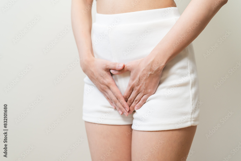 Close-up young woman hand holding crotch suffering from itchy or scratch of vagina isolated on background. Close-up young woman hand holding crotch suffering from itchy or scratch of vagina isolated on background.