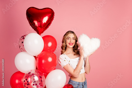 Photo portrait of lovely woman balloons hold heart fluffy pillow dressed stylish white garment hairdo isolated on pink color background