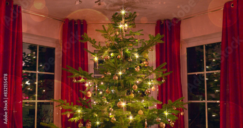 Decorated Christmas tree on blurred, sparkling and fairy background
