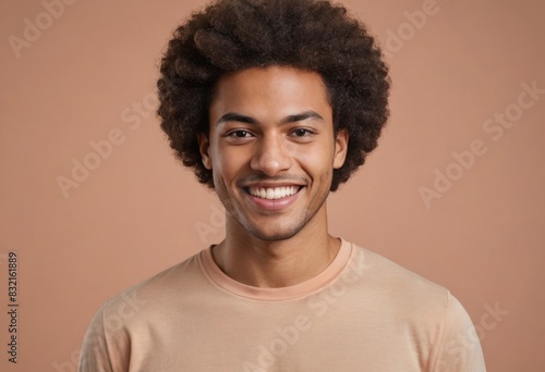 A man with a joyful expression and curly hair wears a beige shirt, his smile exudes warmth and positivity.