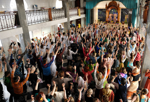 Obraz na plátně Hare Krishnas praying in a temple, their hands up