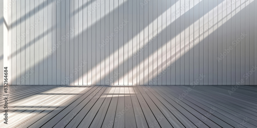Obraz premium Minimalist interior with sunlight streaming through windows creating long shadows on a wooden floor and white paneled walls emphasizing simplicity and elegance 