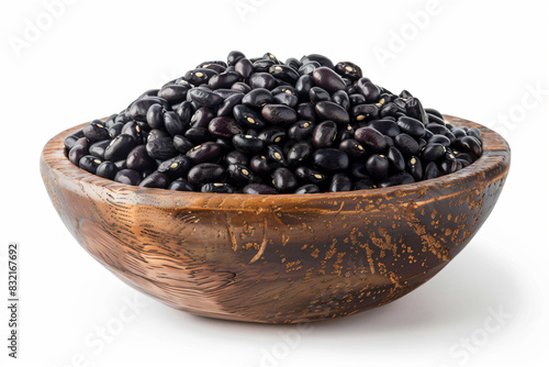 a wooden bowl filled with black beans on a white surface