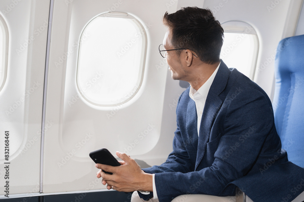 Airplane, travel and portrait of businessman working on laptop computer and smartphone while sitting in airplane. Airplane, travel and portrait of businessman working on laptop computer and smartphone while sitting in airplane.