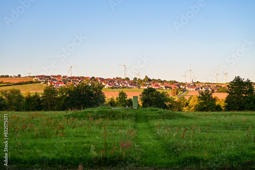 Ausblick auf das Dorf Forst im Sonnenuntergang mit blauem Himmel ohne Wolken, bei Schweinfurt, Franken, Bayern, Deutschland photo