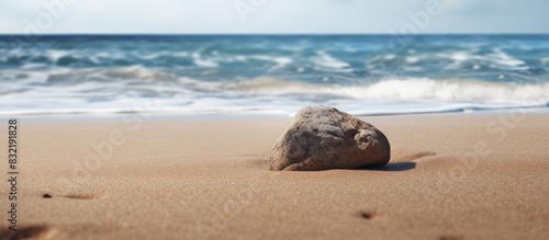 A rock on a sand beachA A A flat tip of rock protruding through sand on beach. Creative banner. Copyspace image photo
