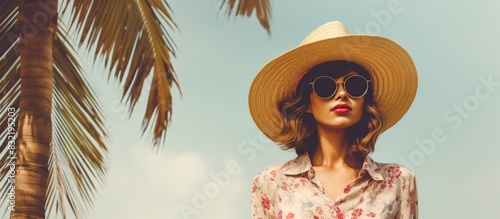 Woman in sunglasses near palm tree wearing hat. Creative banner. Copyspace image photo