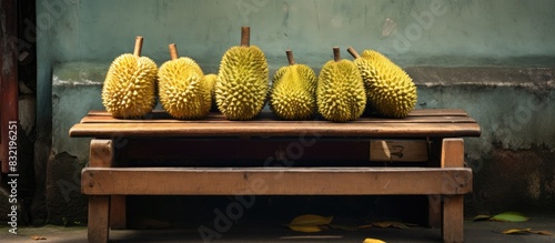 Fototapeta Naklejka Na Ścianę i Meble -  Durian fruits put on the wooden bench of street side vendor seller and ready to eat Images. Creative banner. Copyspace image