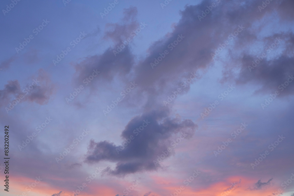 The image displays a serene twilight sky with soft pink and purple hues accented by dark, wispy clouds. The image displays a serene twilight sky with soft pink and purple hues accented by dark, wispy clouds.