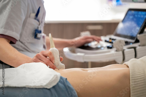 A medical professional conducts an ultrasound examination on a patient lying down, the ultrasound probe on the patient's abdomen.