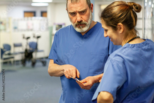 Medical professionals in scrubs discussing photo