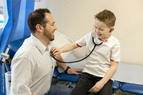 Child playing doctor with an adult doctor photo