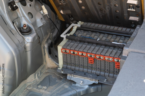 High-voltage traction battery cells installed on a vehicle with a hybrid powertrain. Contacts with corrosion and green oxidation. High-tech transport repair concept.
