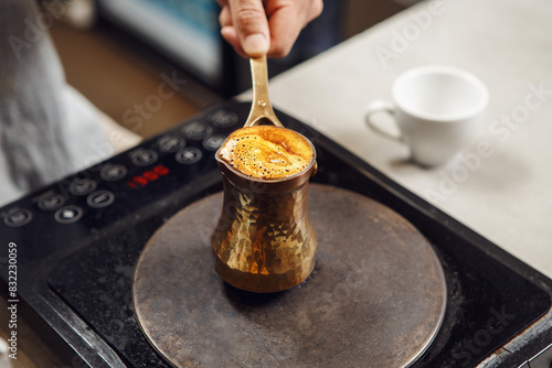 Brewing Turkish Coffee in Traditional Cezve on Electric Stove photo