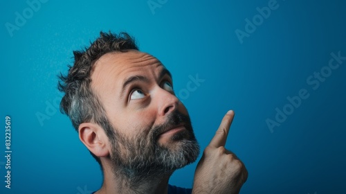 Man contemplating choices and choice in studio on blue background with questions. Thinking, problem-solving, and remembering on mock-up space