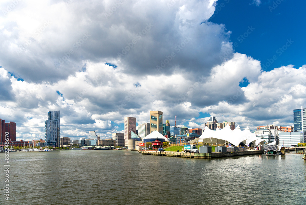 Fototapeta premium Panoramic view of the Baltimore Pier and Inner Harbor and skyscrapers against a blue sky with low clouds.