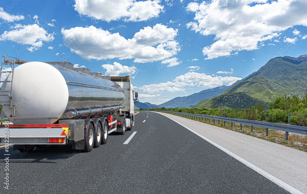 Fuel truck on a picturesque road. A silver tank truck transports fuel.