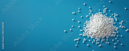 Scattered white pellets of sugar substitute on blue background photo