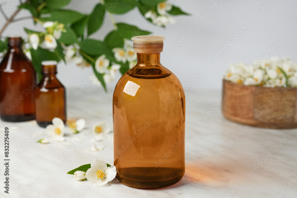 Small glass bottle of jasmine tincture(water infusion, extract, perfume). Jasmine essential oil. Fragrant flower for perfumery, cosmetics production. Side view, product place. Small glass bottle of jasmine tincture(water infusion, extract, perfume). Jasmine essential oil. Fragrant flower for perfumery, cosmetics production. Side view, product place.