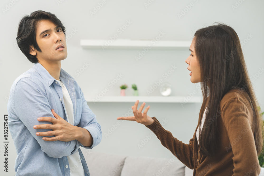 Asian young couple fight standing on white background, relationship in trouble. Different angry, use emotion shouting at each other. Argue husband has expression of disappointment and upset with wife. Asian young couple fight standing on white background, relationship in trouble. Different angry, use emotion shouting at each other. Argue husband has expression of disappointment and upset with wife.