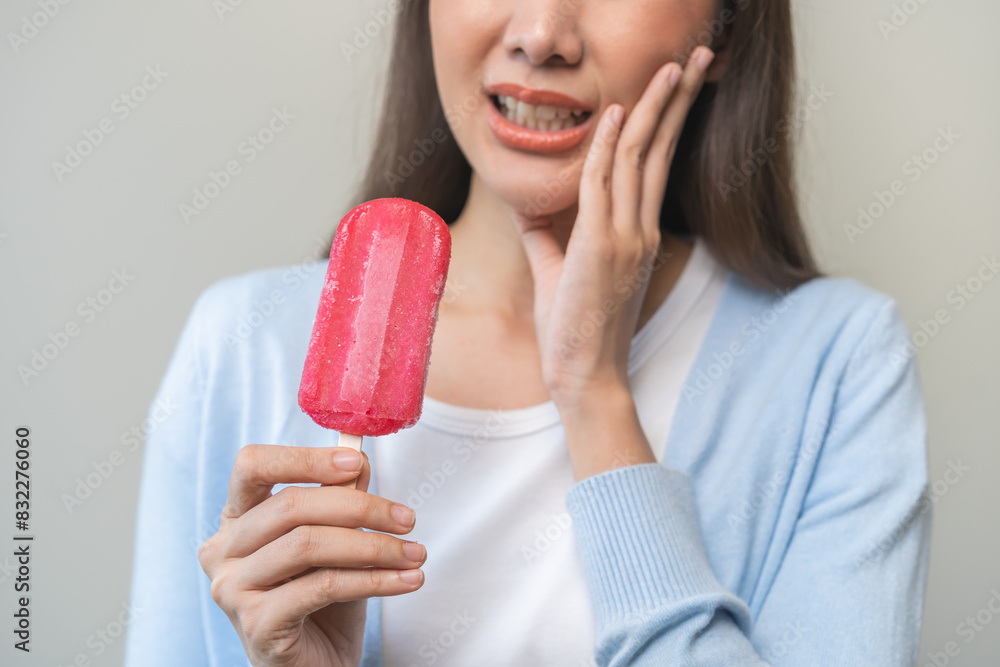 Face expression suffering from sensitive teeth and cold, asian young woman, girl hand touching cheek, hurt or pain eating ice cream. Toothache molar tooth, dental problem isolated on white background. Face expression suffering from sensitive teeth and cold, asian young woman, girl hand touching cheek, hurt or pain eating ice cream. Toothache molar tooth, dental problem isolated on white background.