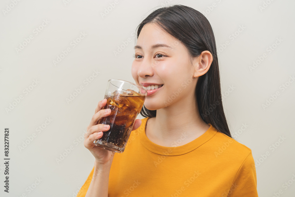 Smile happy thirsty asian young woman, girl drink or sip, holding glass of cold sparkling soda, cola water with ice, refreshness people, isolated on background. Temptation of food and beverage concept Smile happy thirsty asian young woman, girl drink or sip, holding glass of cold sparkling soda, cola water with ice, refreshness people, isolated on background. Temptation of food and beverage concept