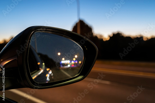 Sparkling and defocused vehicle lights in rear vision mirror at night.