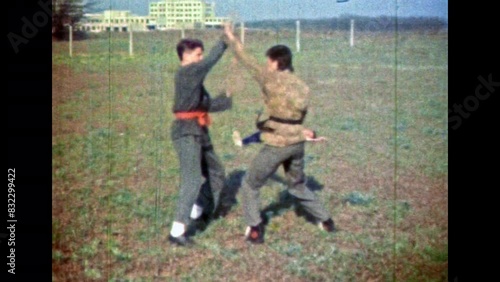 Karate sparring between professional man athlete fighters. Martial workout training with aikido partner. Two men martial combat fighting in green nature outdoor. Vintage film. Retro 1980s archive