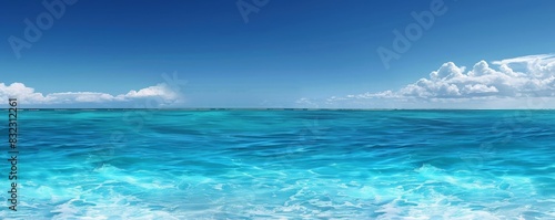 Panoramic view of a pristine turquoise ocean with clear blue sky, showing waves peacefully rolling towards the horizon on a sunny day.