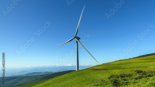 A lone wind turbine standing on a lush green hill, with a clear blue sky in the background.  © Muhammad