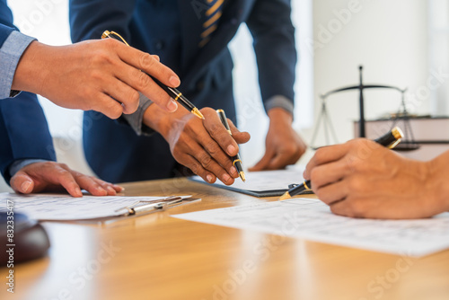 Slika na platnu A team meeting of business people and a lawyer in formal suits is taking place at a desk, discussing a contract and various aspects of the law and litigation