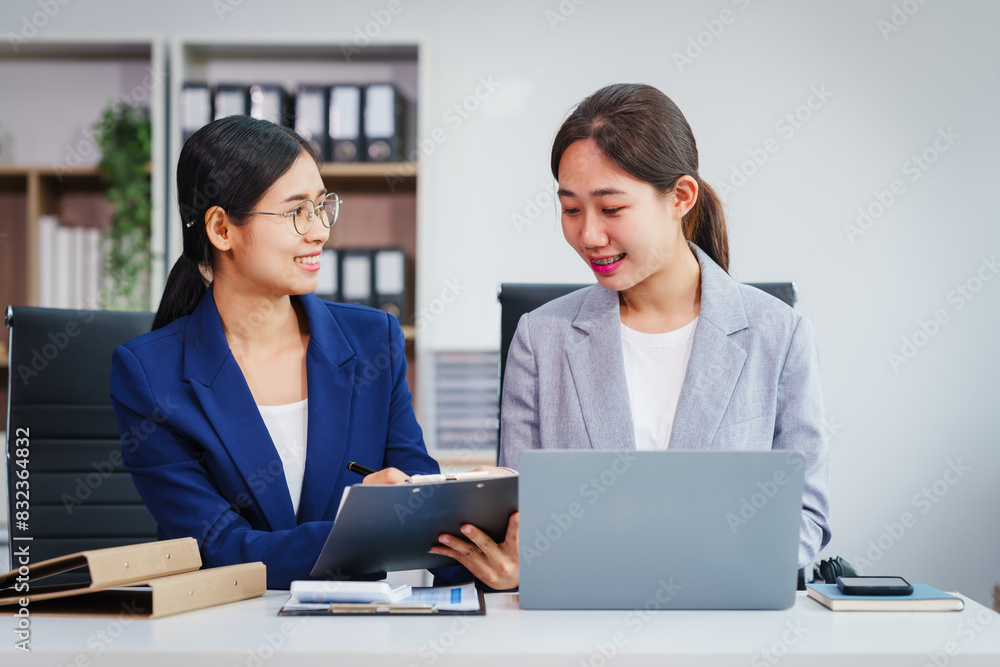 Two Asian businesswomen collaborate on stock market strategies and financial services, exchanging comments and suggestions on loan applications and investment opportunities. Two Asian businesswomen collaborate on stock market strategies and financial services, exchanging comments and suggestions on loan applications and investment opportunities.
