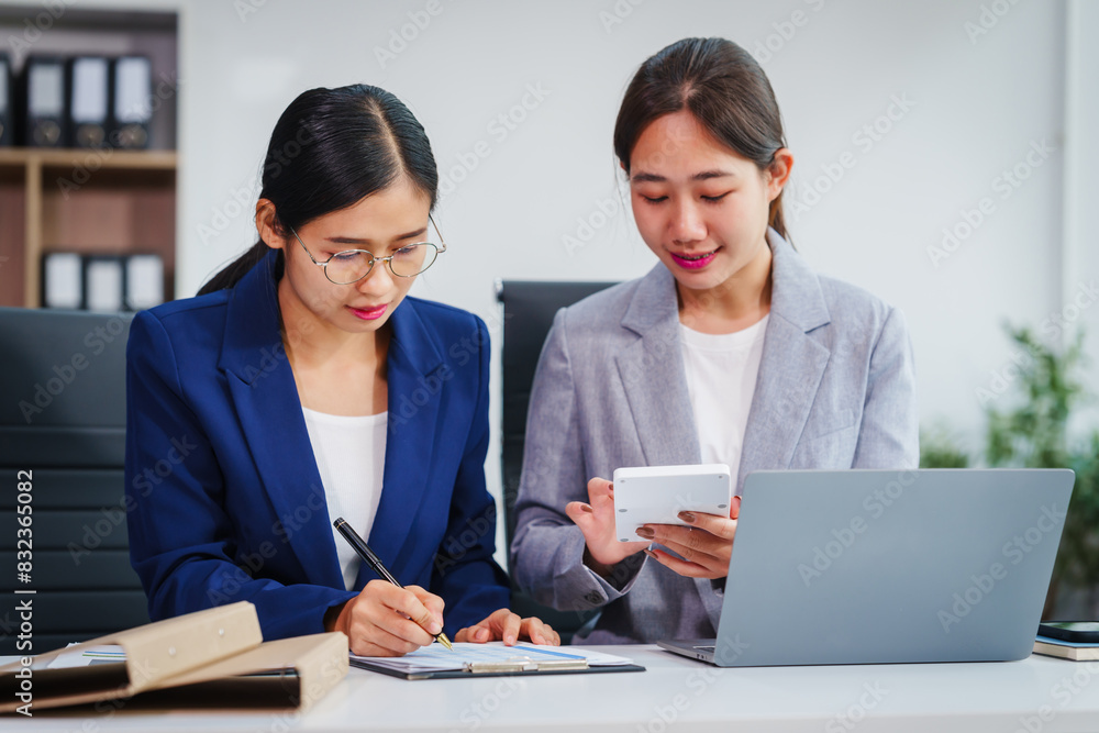 Two Asian businesswomen collaborate on stock market strategies and financial services, exchanging comments and suggestions on loan applications and investment opportunities. Two Asian businesswomen collaborate on stock market strategies and financial services, exchanging comments and suggestions on loan applications and investment opportunities.